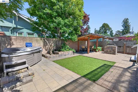 a view of a patio with couches table and chairs under an umbrella