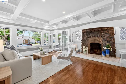 a living room with furniture a fireplace and a floor to ceiling window