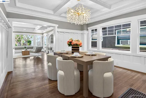 a dining room with wooden floor and a chandelier