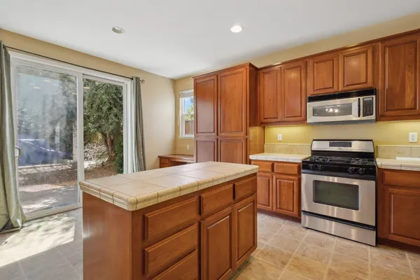 a kitchen with stainless steel appliances granite countertop a stove microwave and refrigerator
