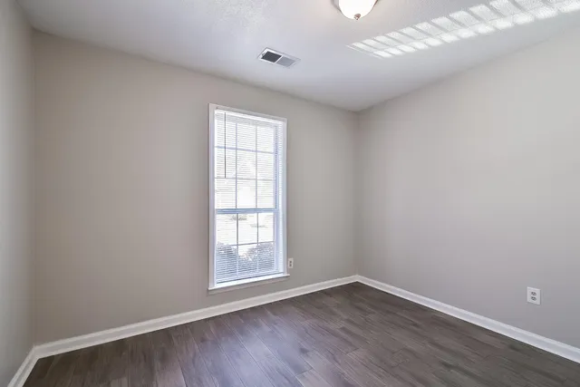 wooden floor in an empty room with a window