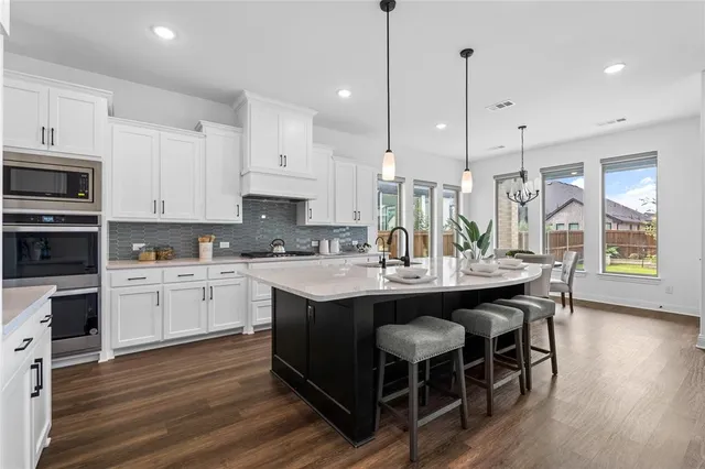 a kitchen with kitchen island granite countertop a sink a center island and cabinets