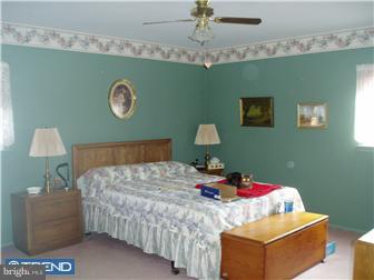 94 Democrat Road Mickleton, NJ 08056 - Photo 8 of 12 a bedroom with a bed and a chandelier
