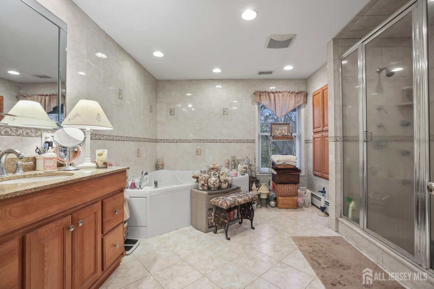 75 Baird Road Millstone Township, NJ 08535 - Photo 16 of 30 a bathroom with a sink double vanity and tub