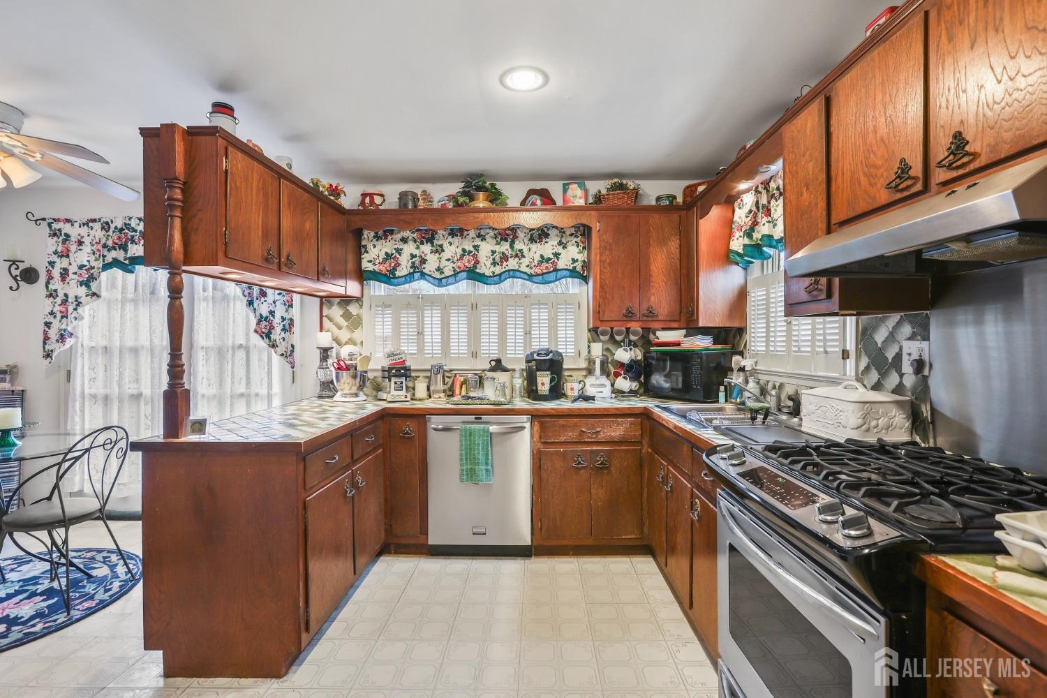75 Baird Road Millstone Township, NJ 08535 - Photo 5 of 30 a kitchen with stainless steel appliances granite countertop a stove a sink dishwasher and cabinets with wooden floor