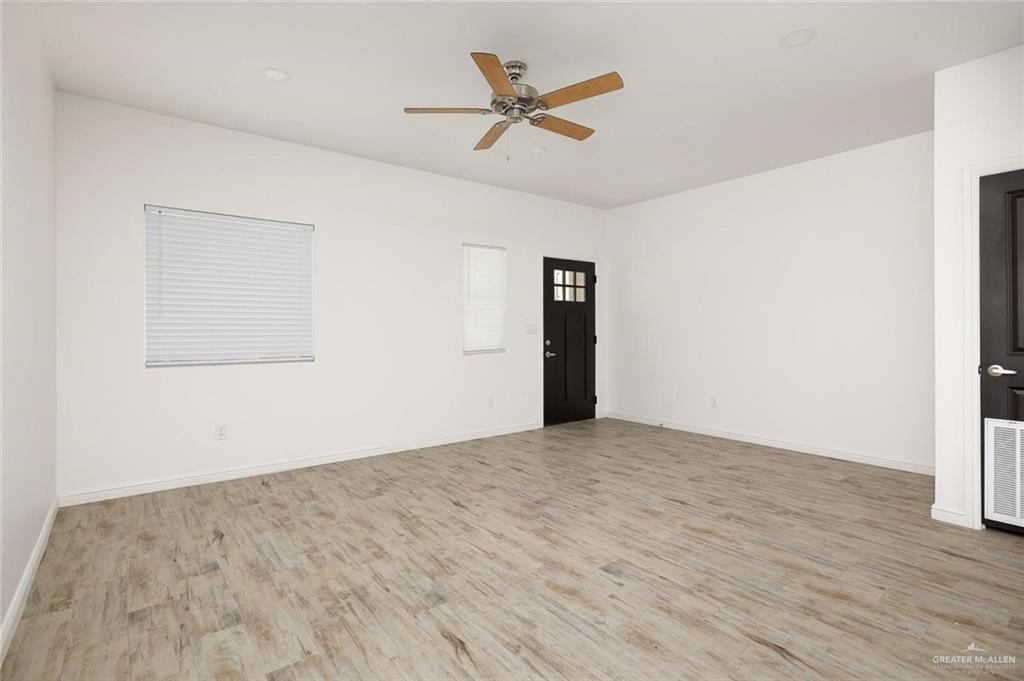 605 Jasper Street, Unit 2 Edinburg, TX 78541 - Photo 2 of 13 an empty room with wooden floor and ceiling fan