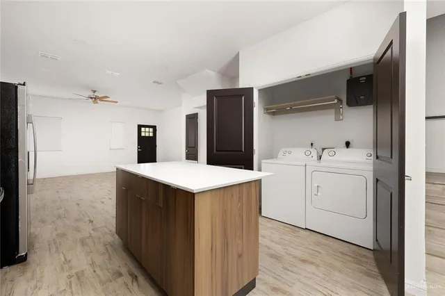 a kitchen with a sink a refrigerator and cabinets