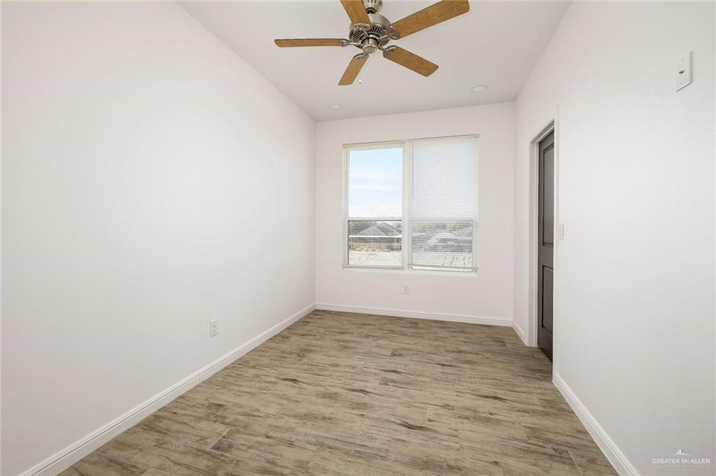 605 Jasper Street, Unit 2 Edinburg, TX 78541 - Photo 8 of 13 an empty room with windows and fan