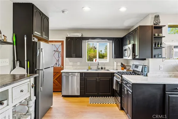 a kitchen with stainless steel appliances granite countertop a sink stove and refrigerator