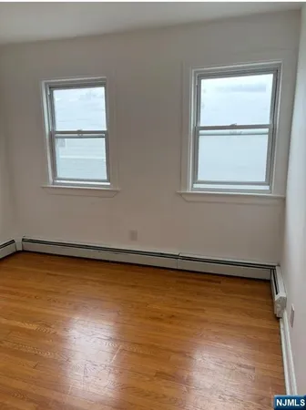 a view of a room with wooden floor and a window