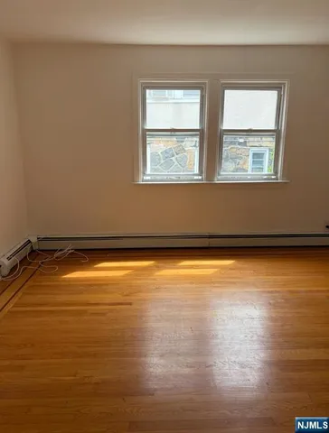 a view of a room with wooden floor and a window