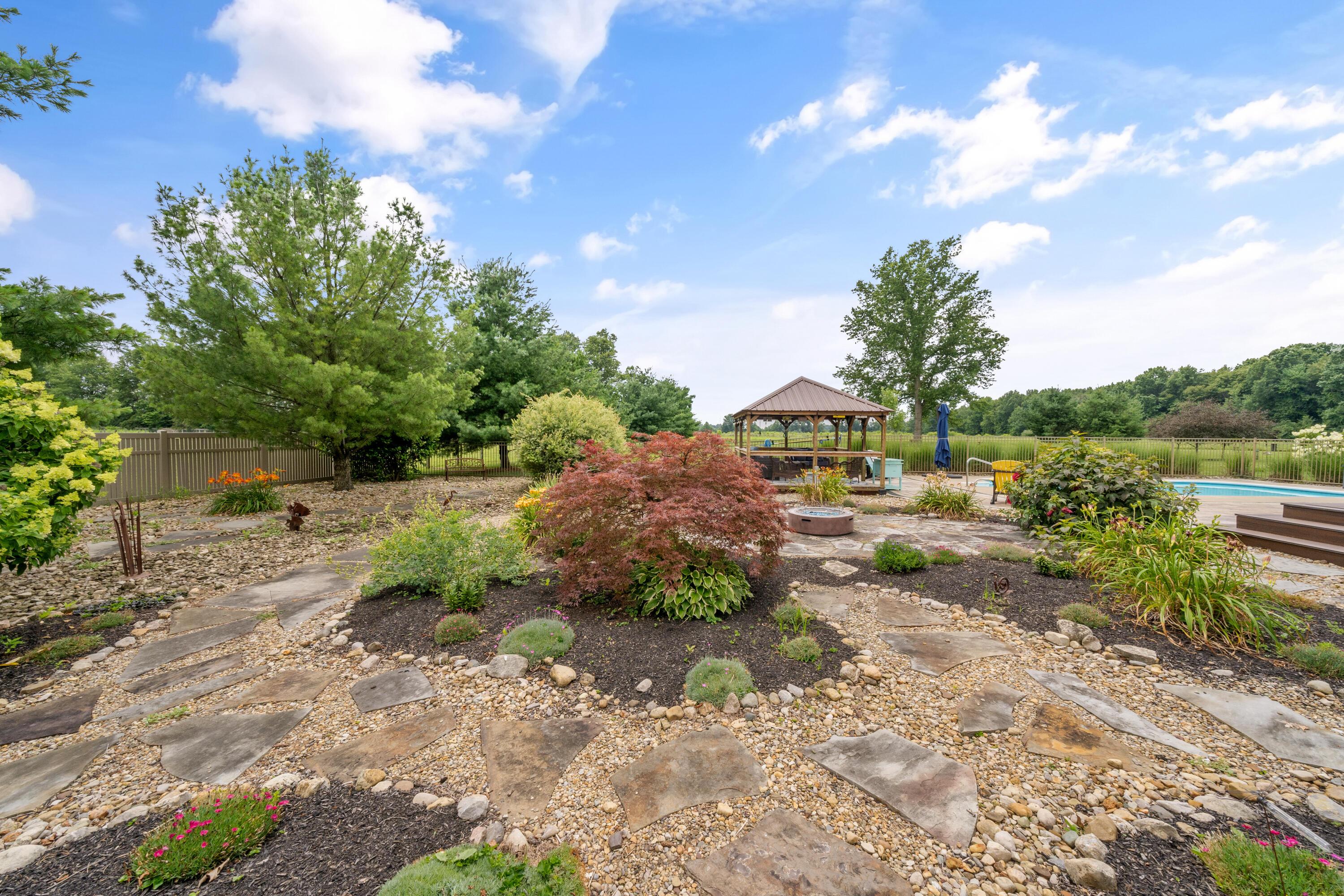 4640 Maynard Road Delaware, OH 43015 - Photo 61 of 91 Landscaped backyard featuring a stone pathway, a gazebo, a fire pit area, and an in-ground pool
