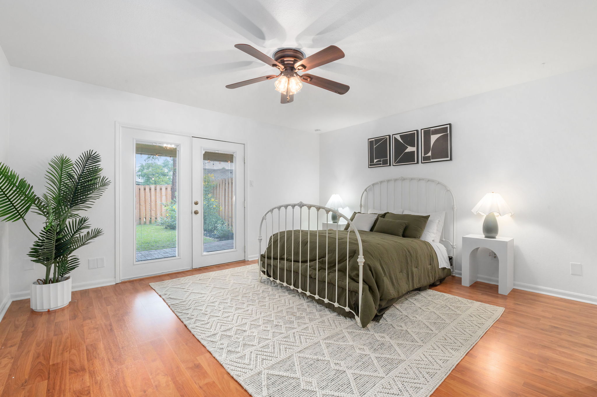 11127 Pinehurst Drive, Unit E Austin, TX 78747 - Photo 11 of 31 a spacious bedroom with a bed a chandelier and a window
