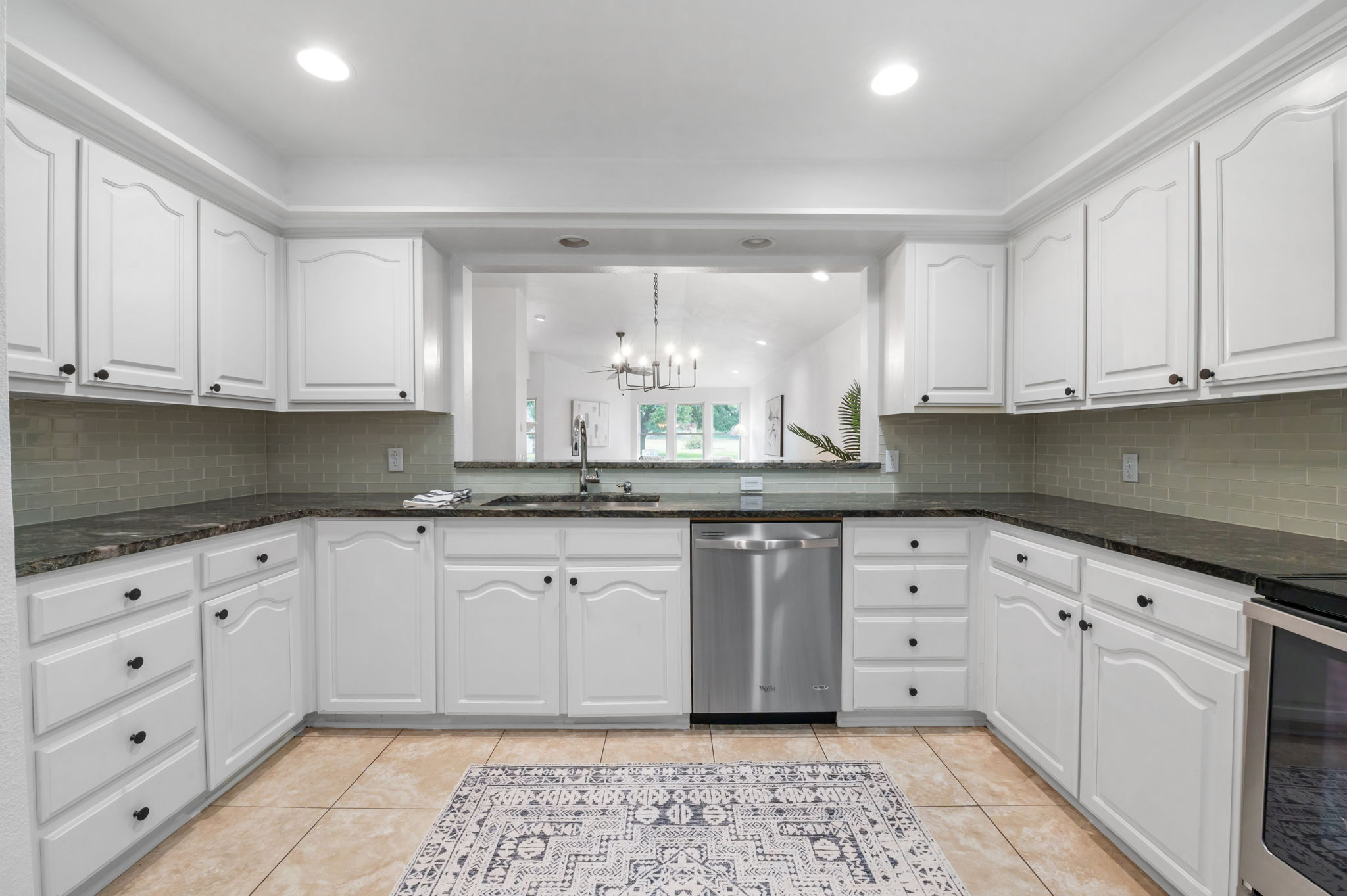 11127 Pinehurst Drive, Unit E Austin, TX 78747 - Photo 10 of 31 a kitchen with granite countertop white cabinets and white appliances