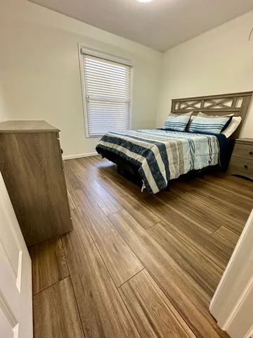 a bedroom with a bed and wooden floor