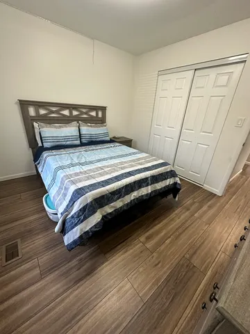 a bedroom with a bed and wooden floor