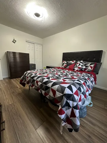 a bedroom with bed and a flat screen tv