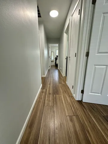 a view of a hallway with wooden floor