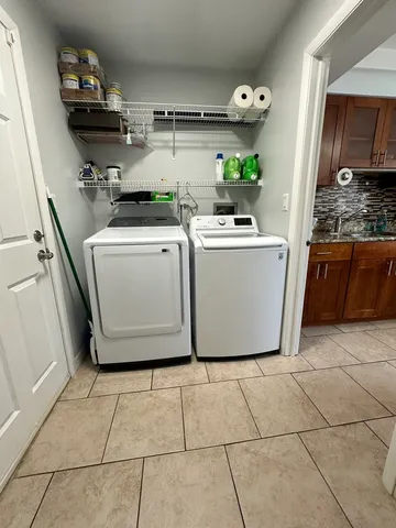 a utility room with cabinets dryer and washer
