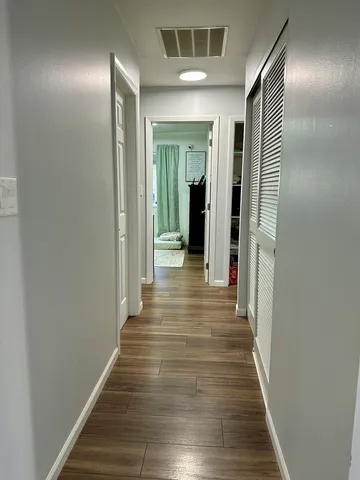 a view of a hallway with wooden floor