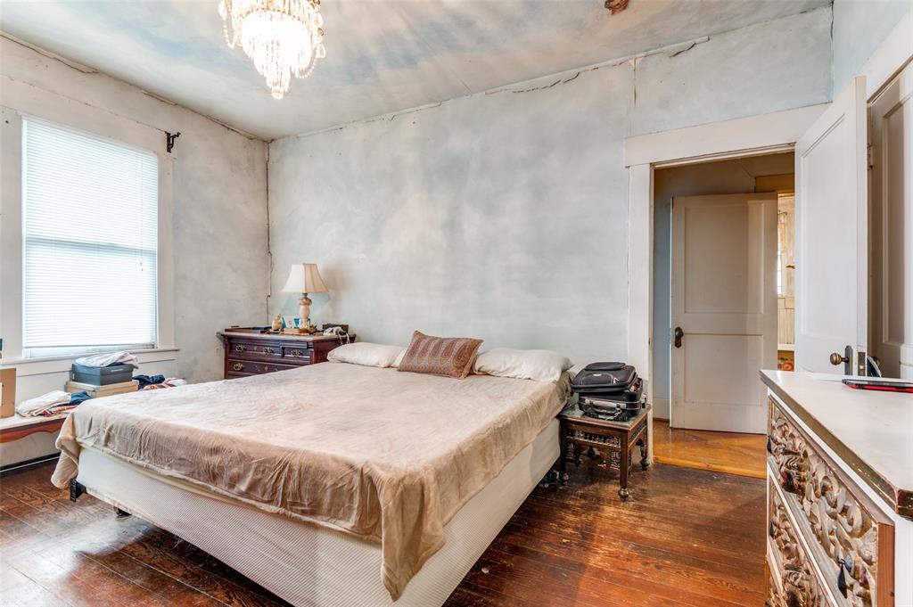 5615 Victor Street Dallas, TX 75214 - Photo 7 of 13 a bedroom with a bed and a chandelier