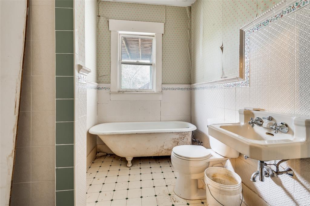 5615 Victor Street Dallas, TX 75214 - Photo 9 of 13 a bathroom with a sink a toilet a mirror and shower