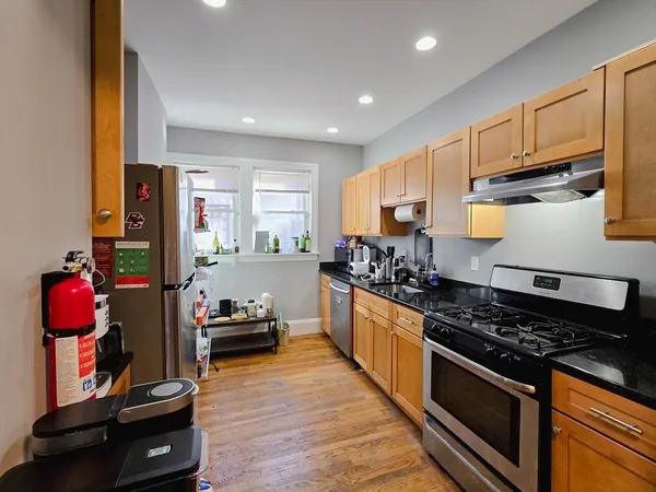 a kitchen with stainless steel appliances granite countertop a stove and a refrigerator