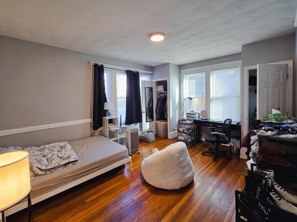 a bedroom with furniture and a wooden floor