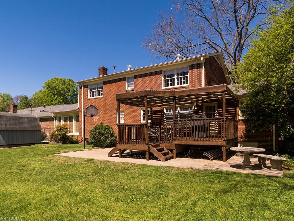 4521 Tower Road Greensboro, NC 27410 - Photo 25 of 28 Backside of the house showing the large concrete patio with the deck/pergola built on the patio.