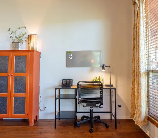 a view of a workspace with furniture and a window