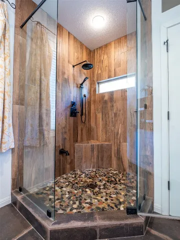 a bathroom with a granite countertop shower a mirror and a sink