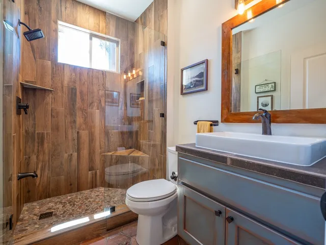 a bathroom with a sink a toilet and shower