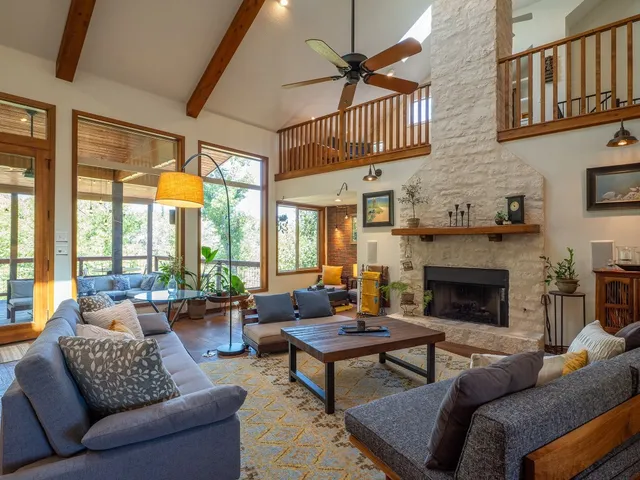 a living room with furniture a fireplace and a large window