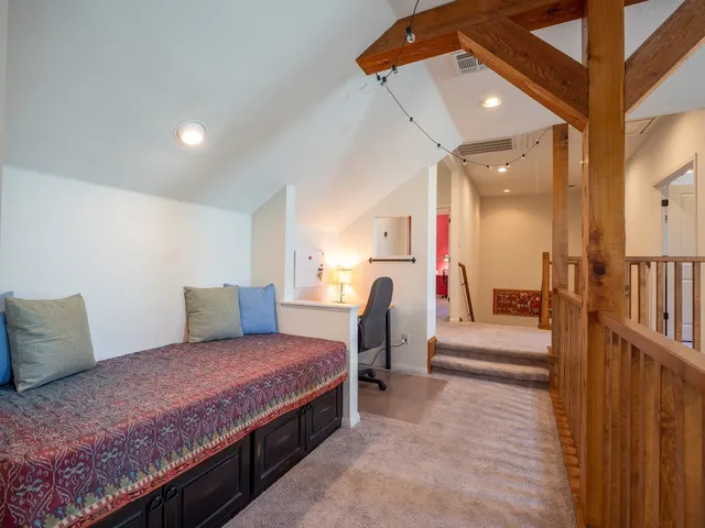 a spacious bedroom with a bed a couch and a potted plant