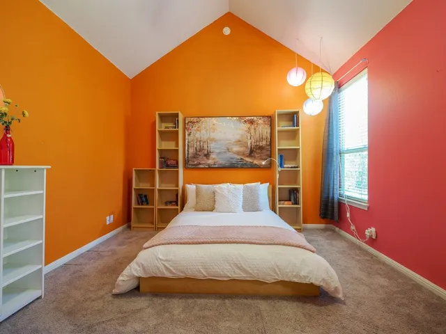 a bed sitting in a bedroom next to a window