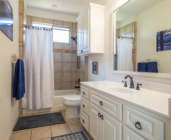 a bathroom with a sink a toilet a mirror and shower