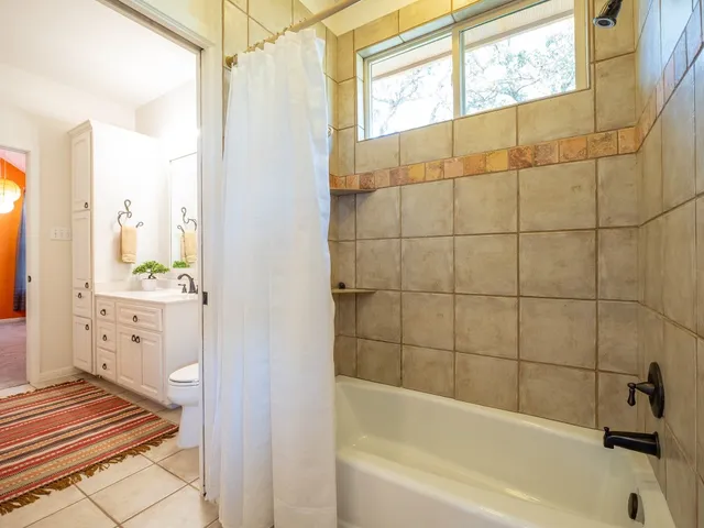 a bathroom with a bathtub a mirror a sink and shower
