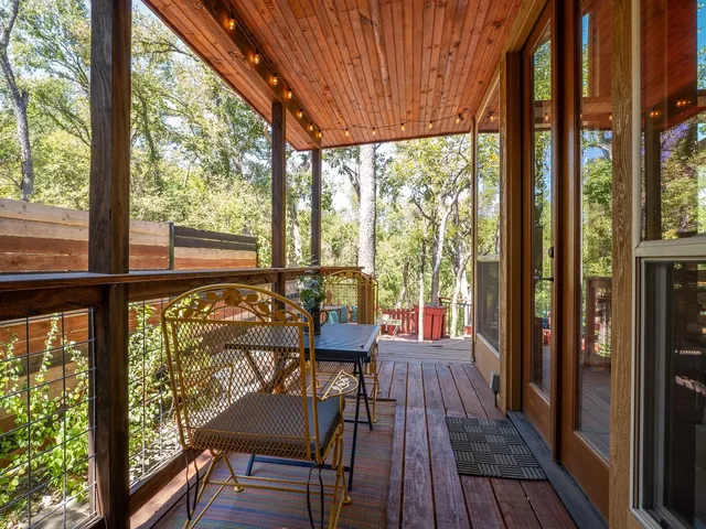 a view of a balcony with chairs and wooden floor