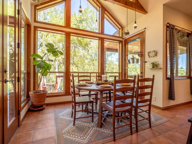 a dining room with furniture and large windows