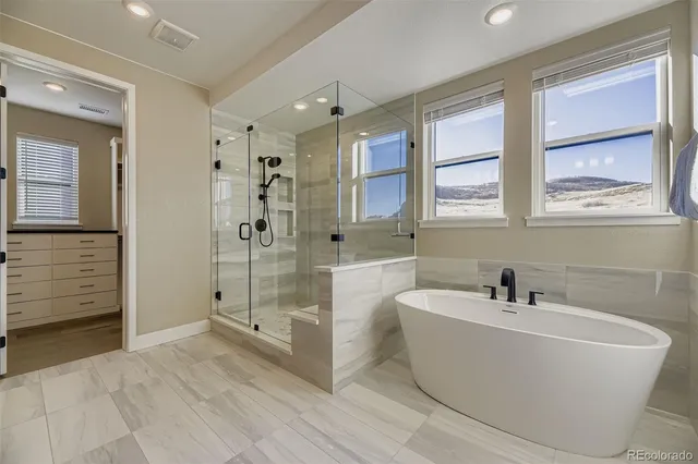 a white bath tub sitting next to a bathroom sink