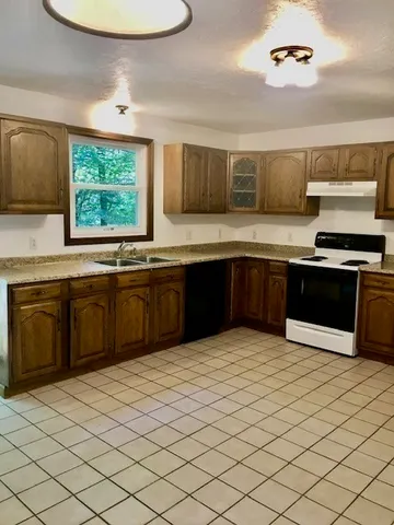 a kitchen with stainless steel appliances granite countertop a sink and a stove