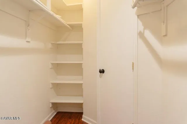 a view of a small space with wooden floor and a window