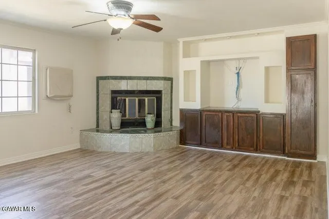 wooden floor fireplace and windows in an empty room