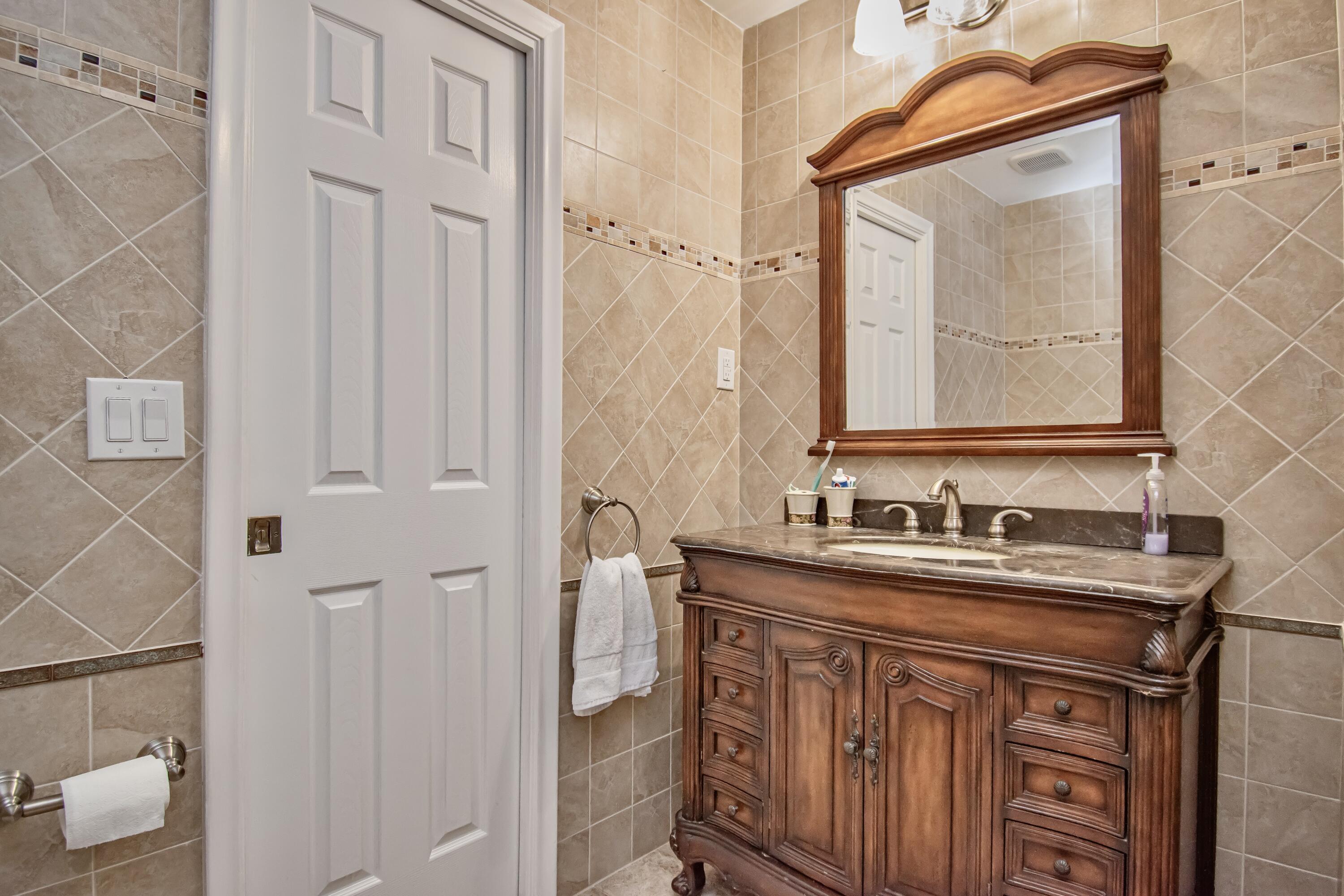 7838 Cypress Crescent Boca Raton, FL 33433 - Photo 19 of 24 a bathroom with a sink a mirror and a vanity