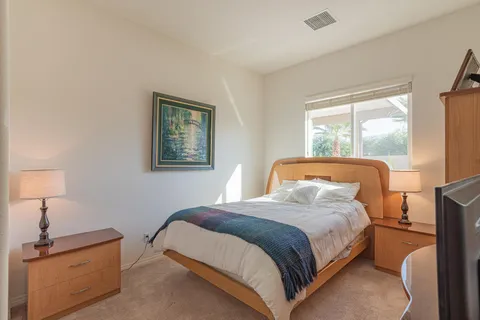 a bedroom with a bed lamp and window