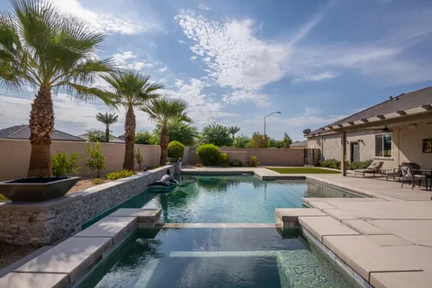 a view of a swimming pool with a patio and a yard