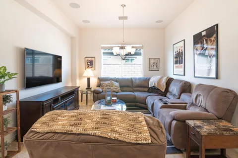 a living room with furniture a flat screen tv and a window
