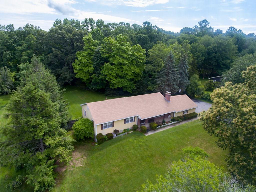 an aerial view of a house with backyard garden and trees