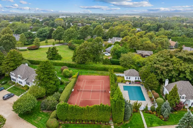 an aerial view of residential houses with outdoor space and trees