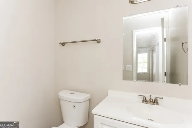a bathroom with a sink a toilet and a mirror